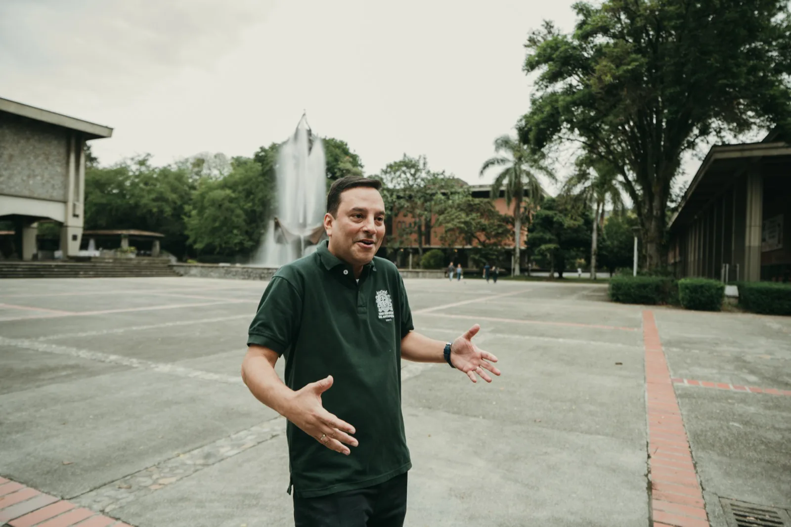 Conversación en la plaza del campus, manos abiertas.